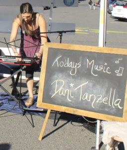 CAMAS MUSICIAN DANI Tanzella sets up for her performance at the Sept. 21 Camas Farmers Market in Historic Downtown Camas. Tanzella, who moved to Camas from Portland in 2010, says she thought she might miss city living but has fallen in love with Camas’ small-town charm and its bustling mid-week farmers market, which Tanzella calls a market that ‘has heart.’