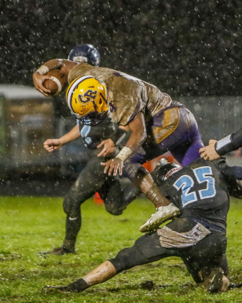 Columbia River defensive back Nathaniel Trevino (4) is tackled by Hockinson wide receiver Matt Henry (25) after making an interception. Photo by Mike Schultz.