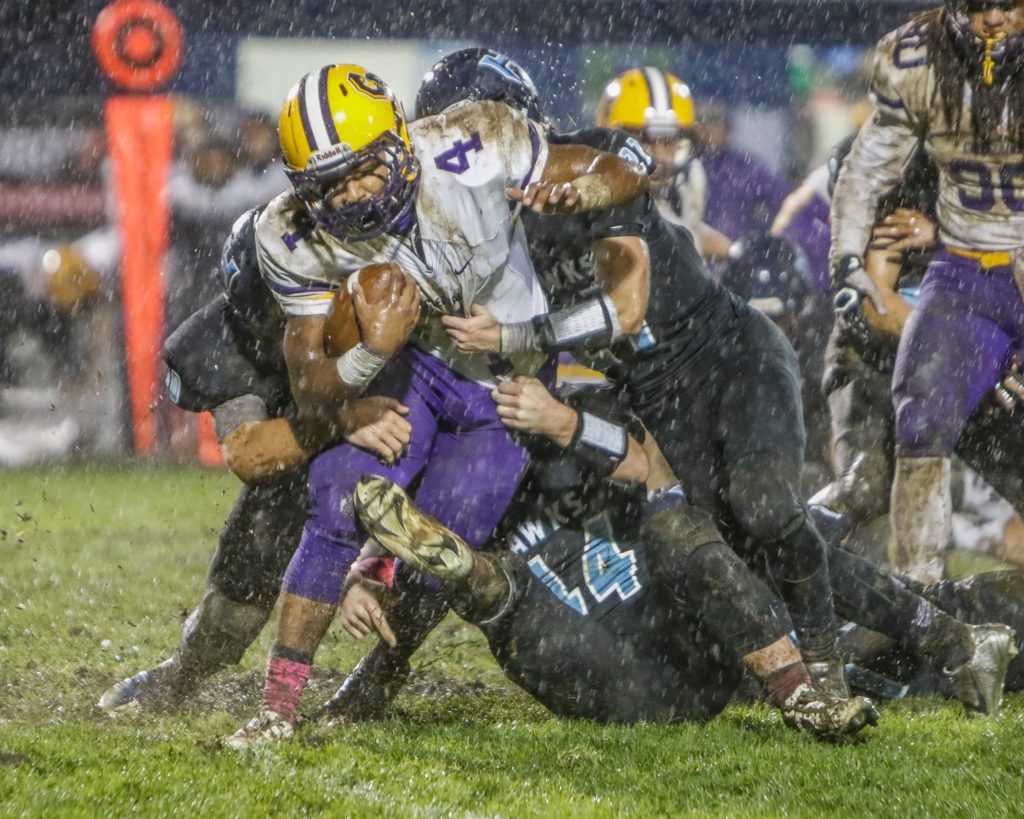 Columbia River running back Nathaniel Trevino (4) is stopped by multiple Hockinson defenders. Photo by Mike Schultz.