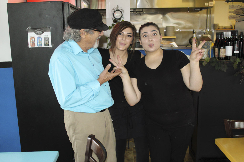 George Vlachos, owner of George’s Molon Lave in Battle Ground, shares a laugh with two of his employees, Rayya Abukhader (right) and Hailey Clearwater (center). Photo by Joanna Yorke