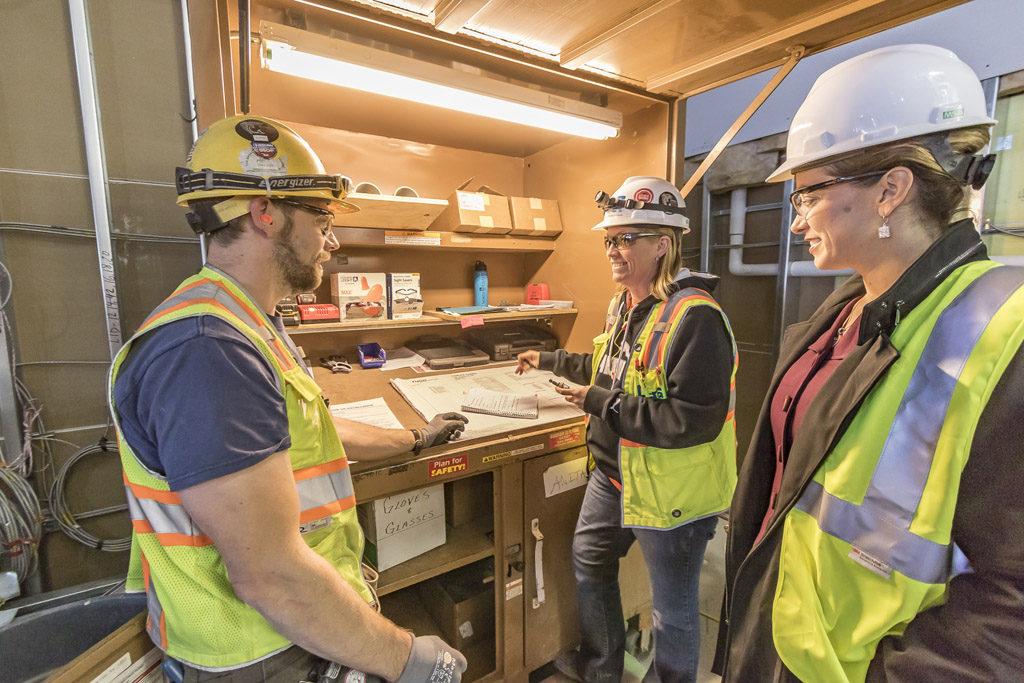 Kara Fox-LaRose (right) consults with Anita Foreman, the electrical foreman for OEG of Portland, and member of the Cowlitz Indian Tribe (center) and Mark Gable, journeyman wireman for OEG (left) at the construction site of the ilani casino-resort on Wed., Oct. 5. Photo by Mike Schultz