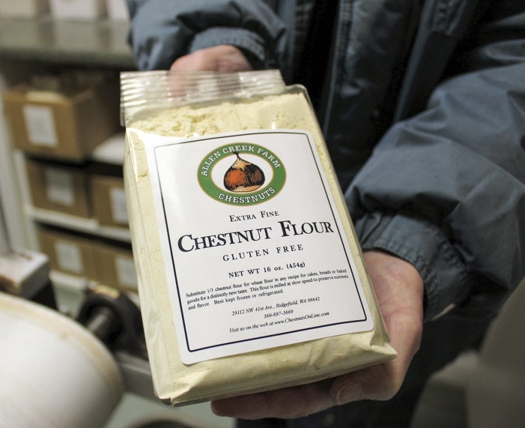 Carolyn Young shows a bag of the sweet-tasting, gluten-free chestnut flour that she and her husband, Ray Young (not pictured) grow and mill at Allen Creek Farm in Ridgefield. Photo by Kelly Moyer