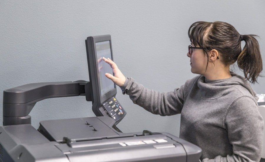 Rebecca Laratta uses the digital press at Ink Ability, Battle Ground’s newest print shop. The shop opened for business on Feb. 6 over in the Battle Ground Plaza. Photo by Mike Schultz