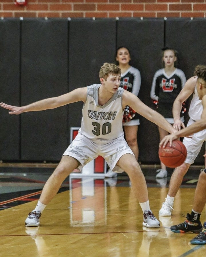 Throughout his basketball career, Union’s Cameron Cranston (30) has continued to improve in all aspects of the game including on defense, as he showed here during a bi-district tournament victory over Olympia Feb. 9 at Union High School. Photo by Mike Schultz