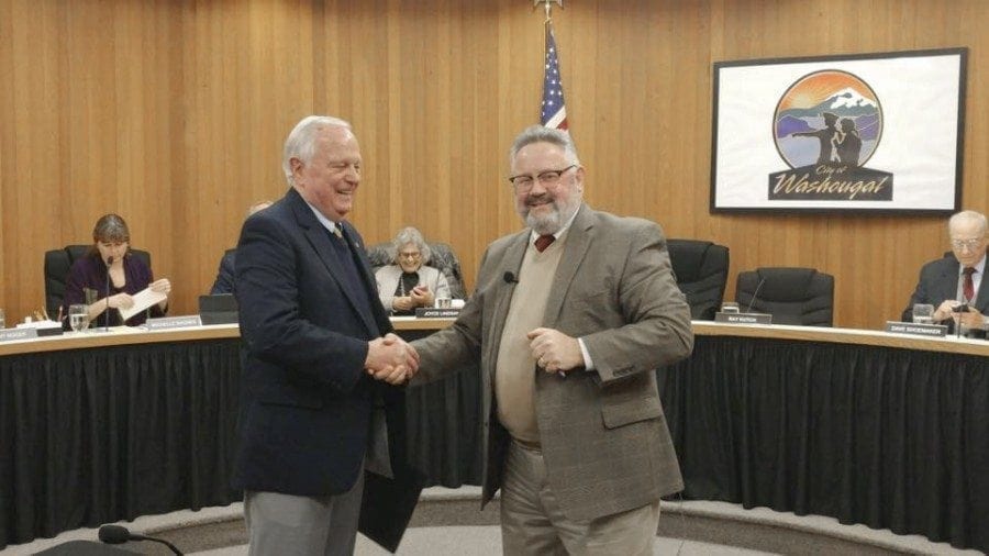 Ray Kutch (left) shakes hands with Washougal Mayor Sean Guard (right) at a council meeting held Tue., Feb. 7, to appoint a city council replacement for councilwoman Jennifer McDaniel, who resigned from the council last month. The council selected Kutch, a former Naval flight officer, Vietnam veteran and longtime Washougal area businessman.