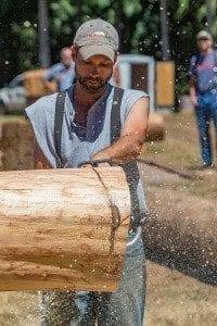 Greg Brown uses his modified saw to cut through a log during the Amboy Territorial Days logging competition Saturday. Photo by Mike Schultz