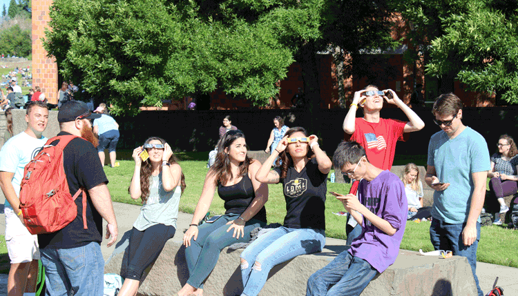 Excited students gaze upward at the progression of the eclipse at a gathering Monday at Washington State University Vancouver. Photo by Alex Peru