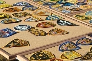 The winner of a live auction Thursday was able to take home a board of patches of their choice from retired police officer Steve Allen’s large collection of police department patches. Photo by Alex Peru