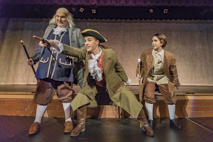 Natalie Williams as Richard Henry Lee (center) makes another point in front of Jordyn Fields’ Benjamin Franklin and Rowan Segura’s John Adams during Heritage’s production of “1776,” now performing at the high school. Photo by Mike Schultz