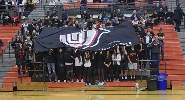 Union High School students unveil the logo during pre-game introductions. The Titans lost in a state regional seeding game, but the fans will be able to bring their banner to the Tacoma Dome next week. Photo by Paul Valencia