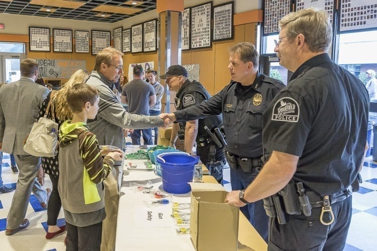 Todd and Noah Swenson meet with Ridgefield police officer Craig Wattson, Chief John Brooks, and Lt. Roy Rhine at Wednesday’s Ridgefield School Safety Open House. Photo by Mike Schultz.