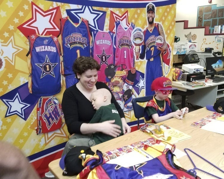Lauren Reagan holds her son Declan while Adrian sports his new glasses provided by the Harlem Wizards. The twin brothers were “signed” by the traveling exhibition basketball club and will be honored at their game Wednesday night at Union High School. Photo by Paul Valencia