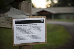 Signs posted on nearly all the entrances to Fort Vancouver’s park tell visitors of the reasons for the closed amenities. Some have had notes added to them, like this one near the visitors center. Photo by Jacob Granneman