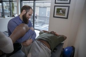 Steven Cabrales, New Athlete’s physical therapist, works with NFL Minnesota Vikings center Cornelius Edison during a therapy session at New Athlete’s adjoining chiropractic space. Photo by Jacob Granneman