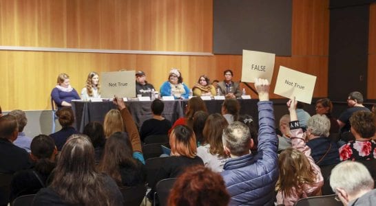 People opposed to Drag Queen Story Hour at Vancouver Community Library hold up signs during a panel on the events put on by the Fort Vancouver Regional Library. Photo by Chris Brown