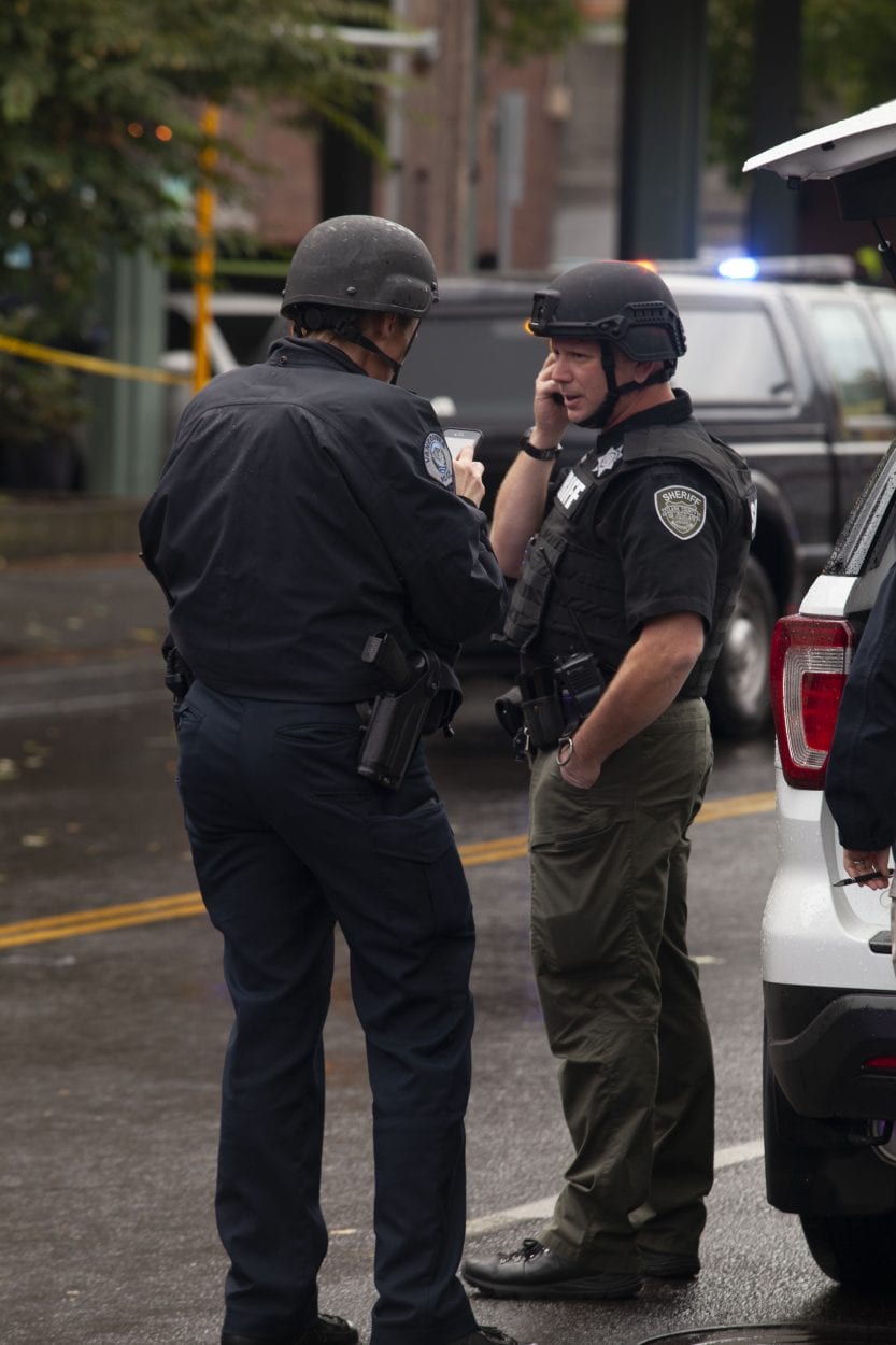 SWAT officers talk outside the Smith Tower in downtown Vancouver after several people were shot there on Thursday afternoon. Photo by Johnny Driver