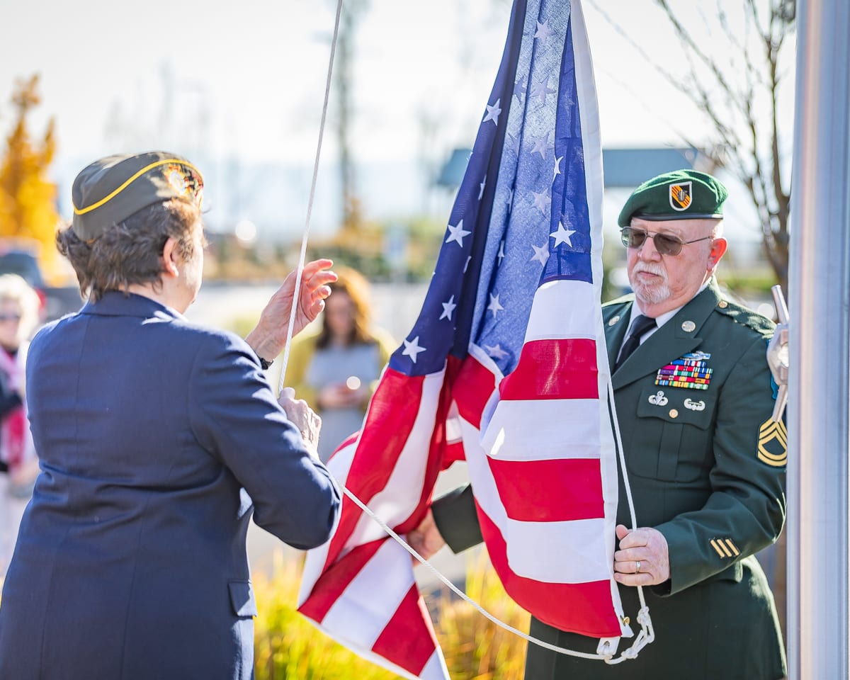 Dana Difford and member Sonny Liston raise The Black Pearl’s newly dedicated flag at the Veterans Day ceremony. Photo by Mike Schultz