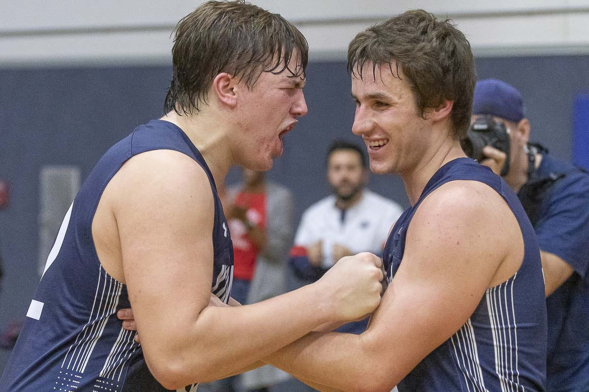 Bailey Meek (left) and Gage Koenders celebrate King’s Way Christian’s victory Thursday night over La Center to win the Trico League boys basketball championship. Photo by Mike Schultz