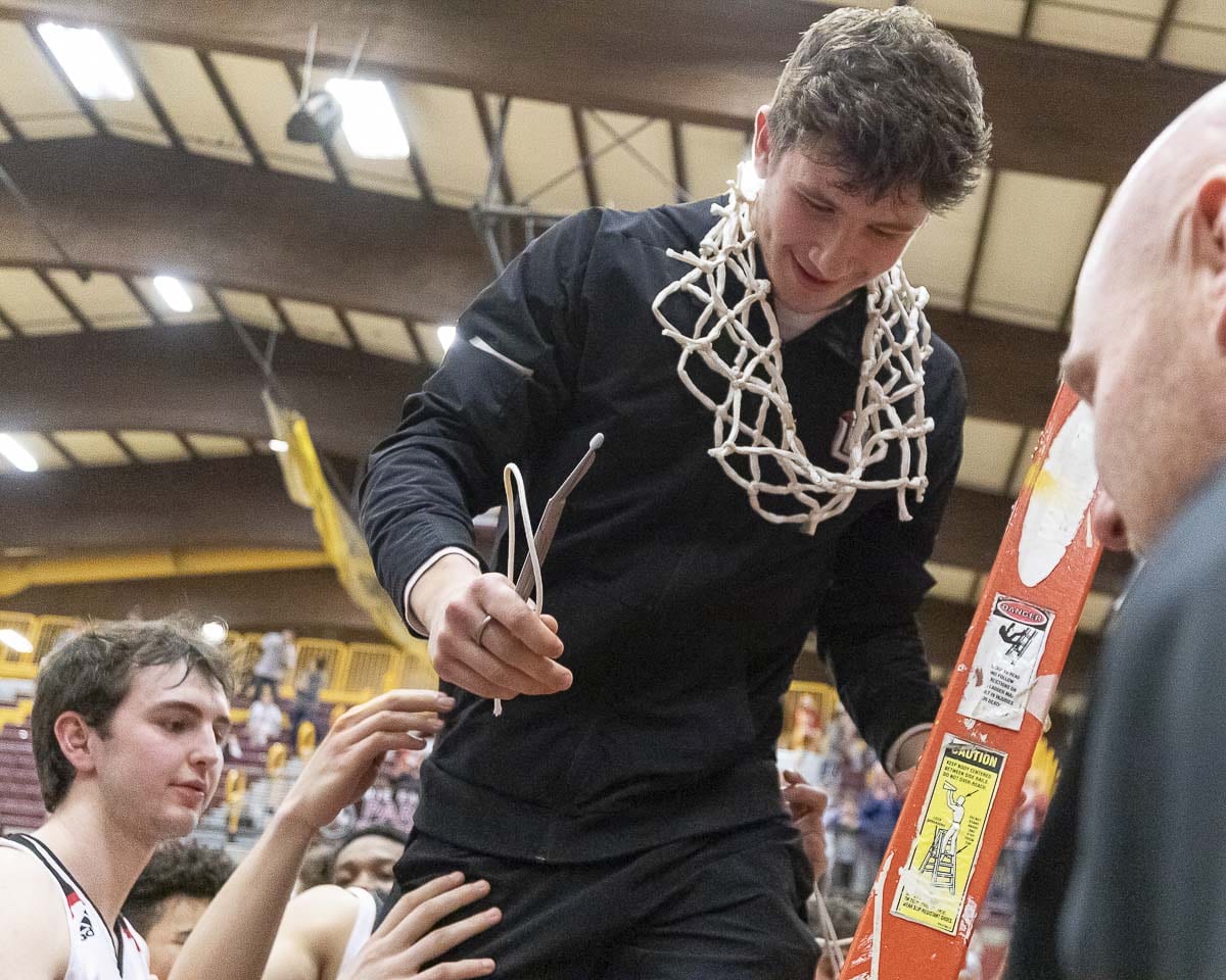 Brad Lackey, who is out for the season with a knee injury, was given the honor to cut down the final piece of the net after Union’s bi-district title Saturday at Prairie High School. Photo by Mike Schultz