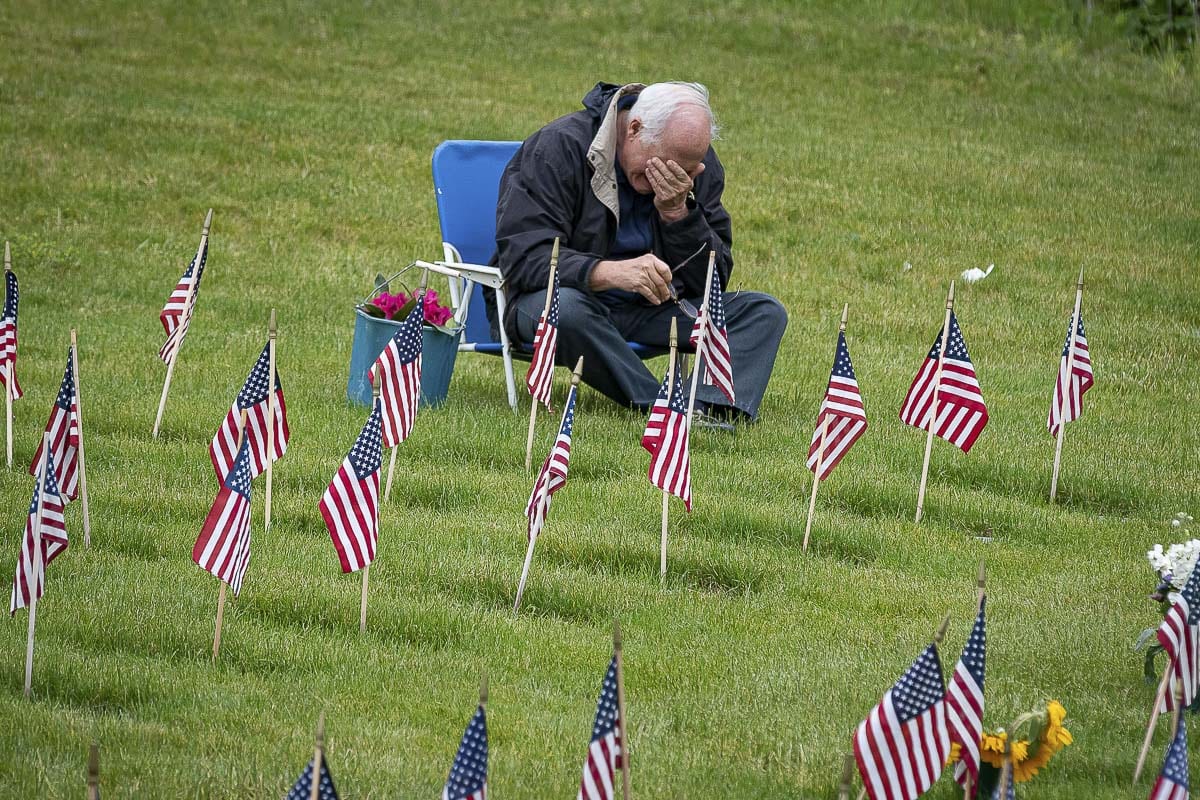 Willamette National Cemetery will be open for visitation from sunrise to sunset on Memorial Weekend. A visitor is shown here grieving during a visit to the cemetery on Memorial Day 2019. Photo by Mike Schultz