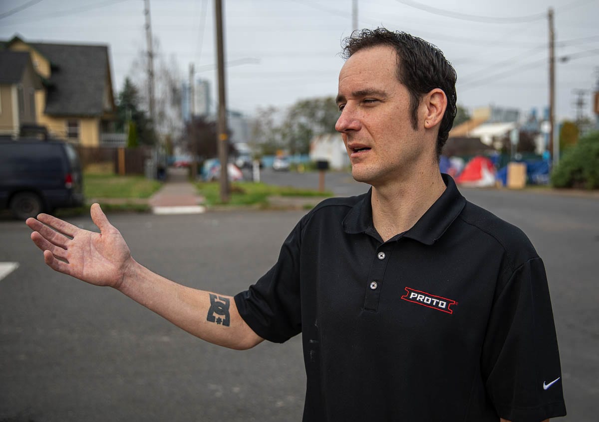 Joe Newsome gestures to his home, which sits on the corner next to the Share House shelter and numerous homeless encampments. Photo by Jacob Granneman