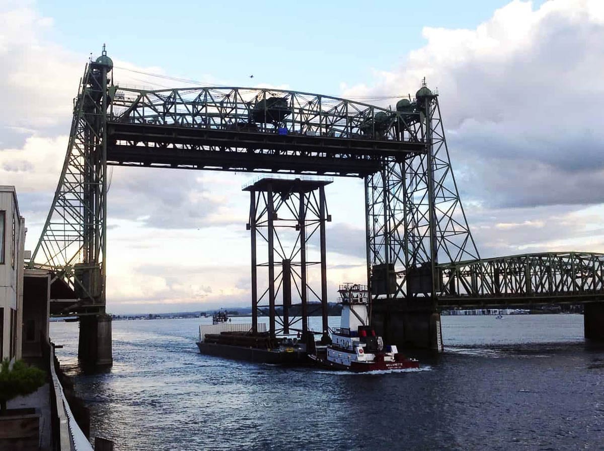 A barge transports a Greenberry project under the Interstate Bridge. Greenberry was offered $25 million in mitigation fees, due to the original CRC bridge being too low to accommodate their needs. Photo by Greenberry Industrial