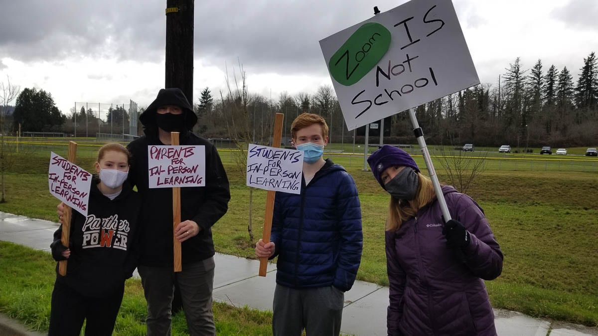 “Zoom is not school” and “Students for in-person learning” were some of the signs people brought to the Washougal rally last week. Photo by John Ley