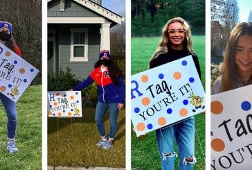 Ridgefield High School cheerleaders lift each other up by playing yard sign tag