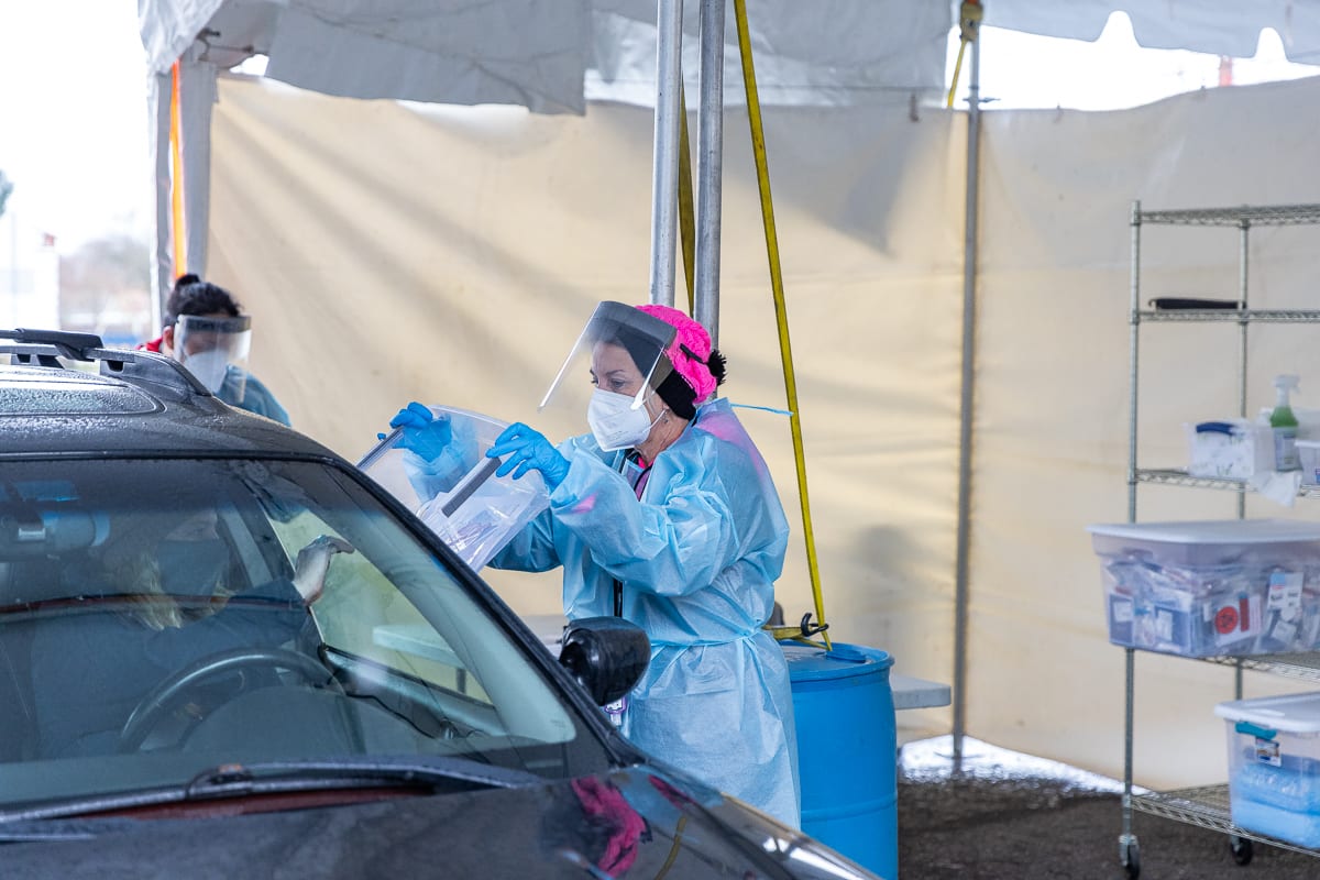 A city of Vancouver employee collects a sample from another city worker during a test run Monday of a no barrier COVID-19 testing site at Tower Mall. Photo by Mike Schultz