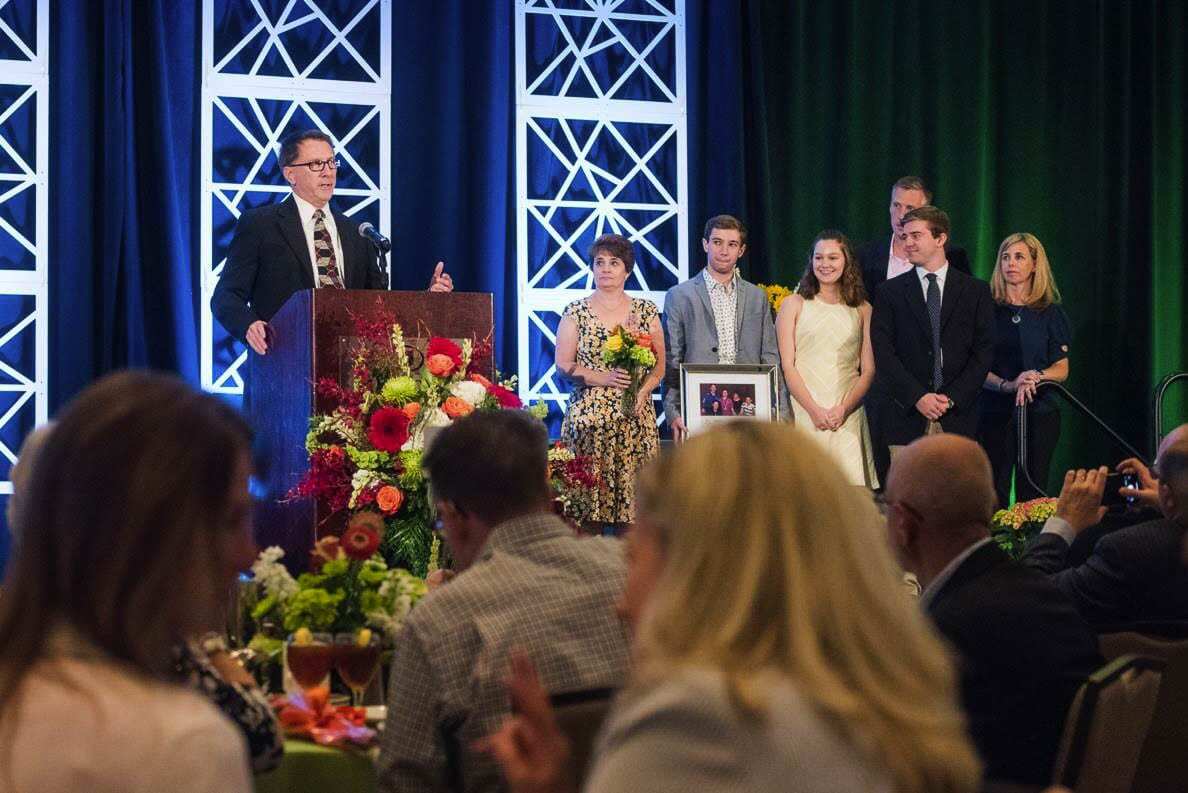 Kevin Ryan, accepts a 2019 Lifetime of Giving Award on behalf of his family, who were recognized jointly for supporting students through scholarship, serving on a string of mission trips and leading local fundraising efforts. To the right, his wife Annemarie looks on alongside their children Tristan, Erin and Aidan (left to right). Kevin Ryan passed away in March of 2020. Photo courtesy of Community Foundation for Southwest Washington