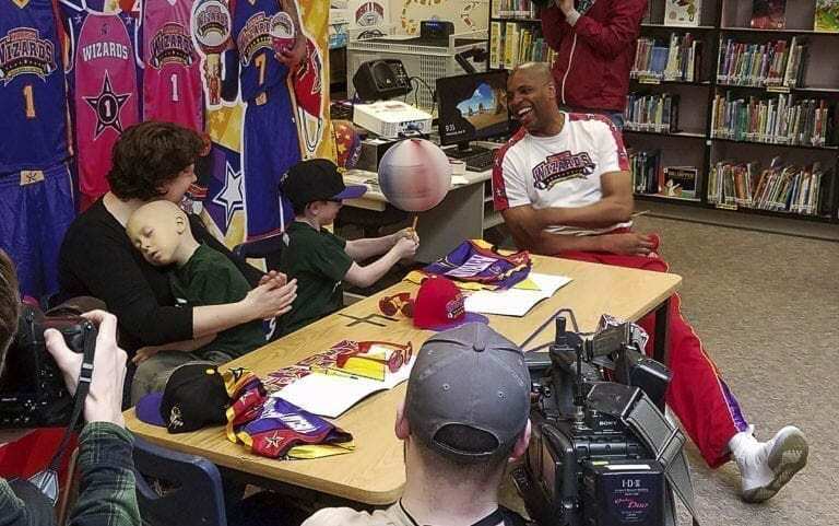 Declan Reagan is in his mother’s arms as Adrian Reagan spins a basketball with the Harlem Wizards in the spring of 2018. Declan and Adrian were “signed” by the Wizards, yet another memory maker in the final months of Declan’s life. Photo by Paul Valencia
