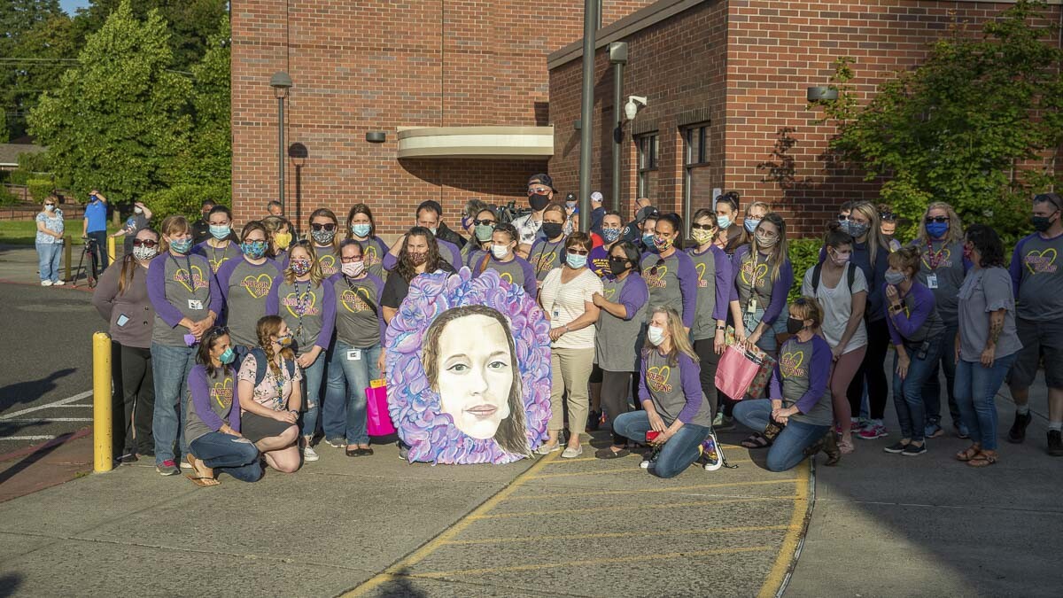 Staff and faculty of Sarah J. Anderson Elementary School pose for a photo with a memorial mural of Tiffany Hill. Photo by Jacob Granneman