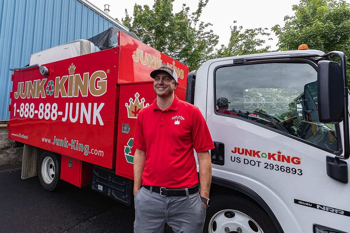 Jason Edge proudly stands in front of his flagship, red Junk King collection truck back in July of 2020. Photo by Mike Schultz