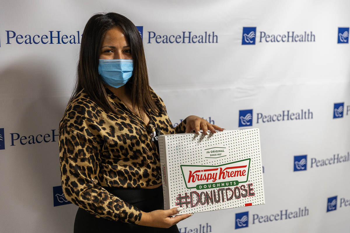 A staff member poses with the #DONUTDOSE box, that each person who becomes fully vaccinated can pose with and then go get free donuts from Krispy Kreme. Photo by Jacob Granneman