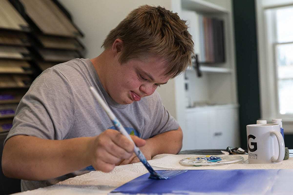 Tommy Tikka loves painting oceans and blue skies. The 19-year-old from Battle Ground has Down’s Syndrome, but that doesn’t stop him from creating magic with a paintbrush. Photo by Mike Schultz.