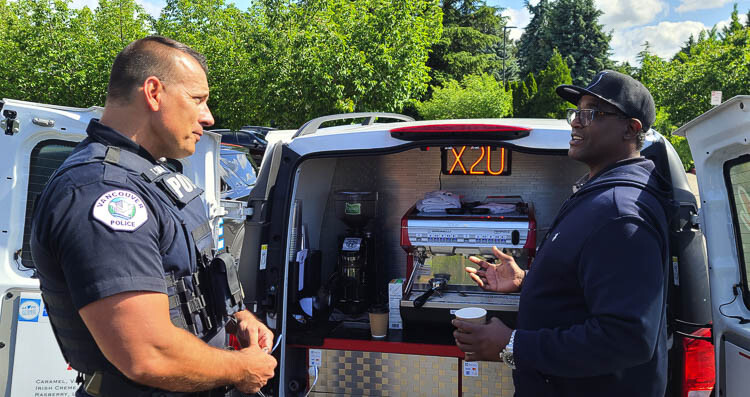 Taylor Smarr of the Vancouver Police Department, talks to Eddie Holford of Xpress 2 U Mobile Cafe on Wednesday. Holford was making coffee for law enforcement officials as part of a police appreciation event. Photo by Paul Valencia