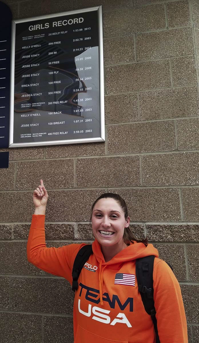 Kara Winger, shown here in 2017, points to a swimming record board at Skyview High School, showing her mark as Kara Patterson. Of course, Winger is more known for her javelin skills. The Skyview graduate qualified for her fourth Olympic Games this weekend. Photo by Paul Valencia