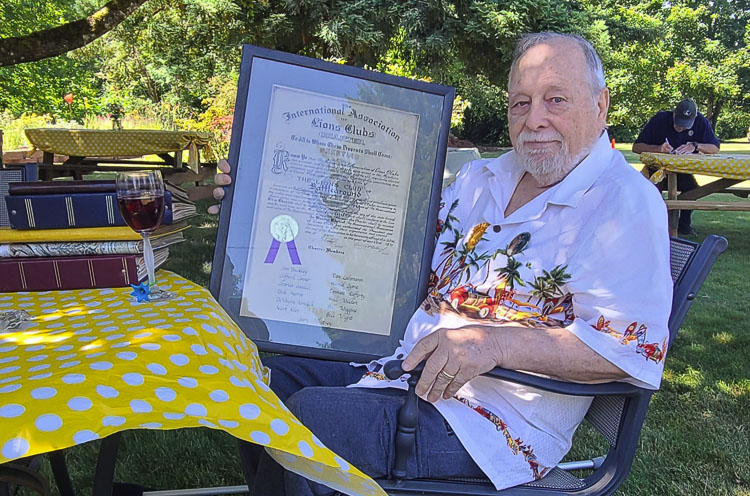 E. Darrell Rafferty holds up the charter proclamation for the Battle Ground Lions Club, established in 1971. Rafferty is an original member of the club, which is celebrating 50 years of community service. Photo by Paul Valencia