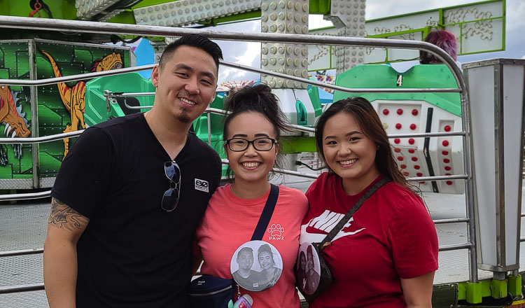 Shong Moua, Kimberly Moua, and Ashley Moua, kept the family tradition going, getting a photo to place on a big button at the carnival. Photo by Paul Valencia