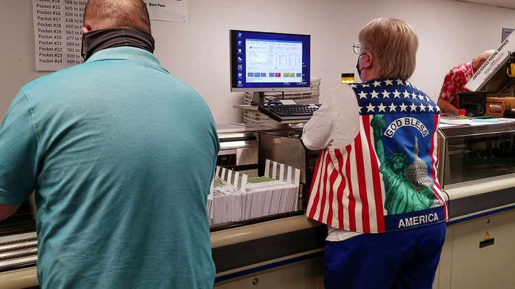 Clark County election workers begin the counting process by placing the ballot envelopes in this machine. It scans the signature on the envelope and captures the unique barcode data tied to each voter. Photo by John Ley