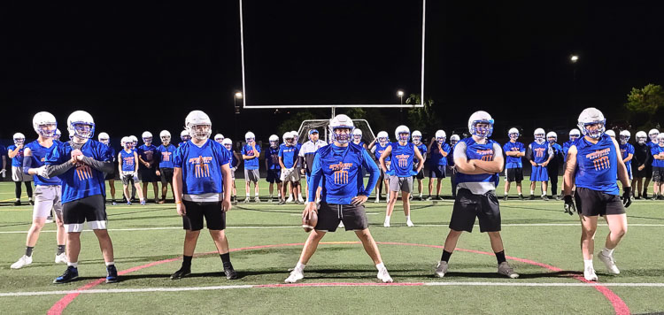 Ridgefield football linemen get ready for the first play in practice during the first practice of the season, just after midnight. Wednesday is the first day of football practice for Washington high school teams. Ridgefield starts as soon as possible. Photo by Paul Valencia