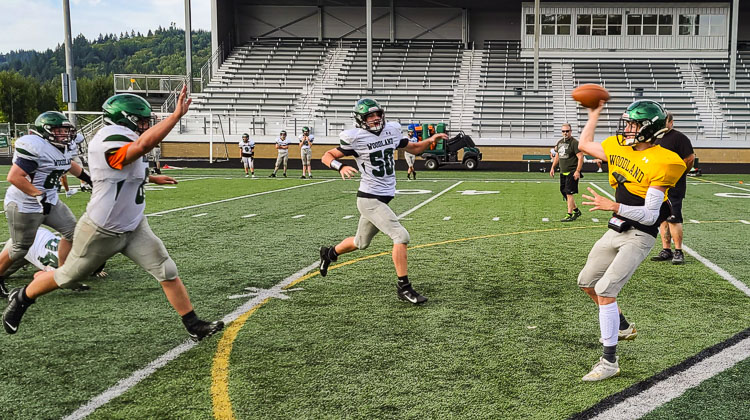 Quarterback Drew Burns gets a screen pass away in time before the pass rush at a recent Woodland practice. Photo by Paul Valencia