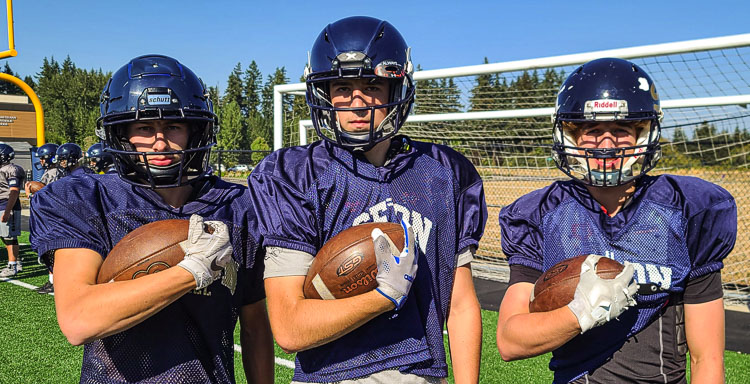 Sean Emberlin, Lance Stuck, and Dax Clifton are thrilled that they have so many teammates this season. In the spring Seton Catholic had 18 players. Now it has 42 on the roster. Photo by Paul Valencia