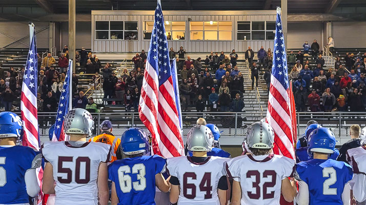 La Center and Montesano players entered the stadium together, carrying flags to salute veterans in attendance. Montesano would go on to beat La Center 42-20 in the Class 1A district football playoff game. Photo by Paul Valencia