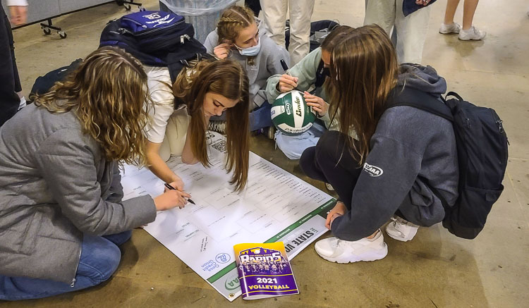 Columbia River volleyball players signed volleyballs, the state bracket, and a program Tuesday, all part of the program’s way of remembering the historic, state championship season. Photo by Paul Valencia