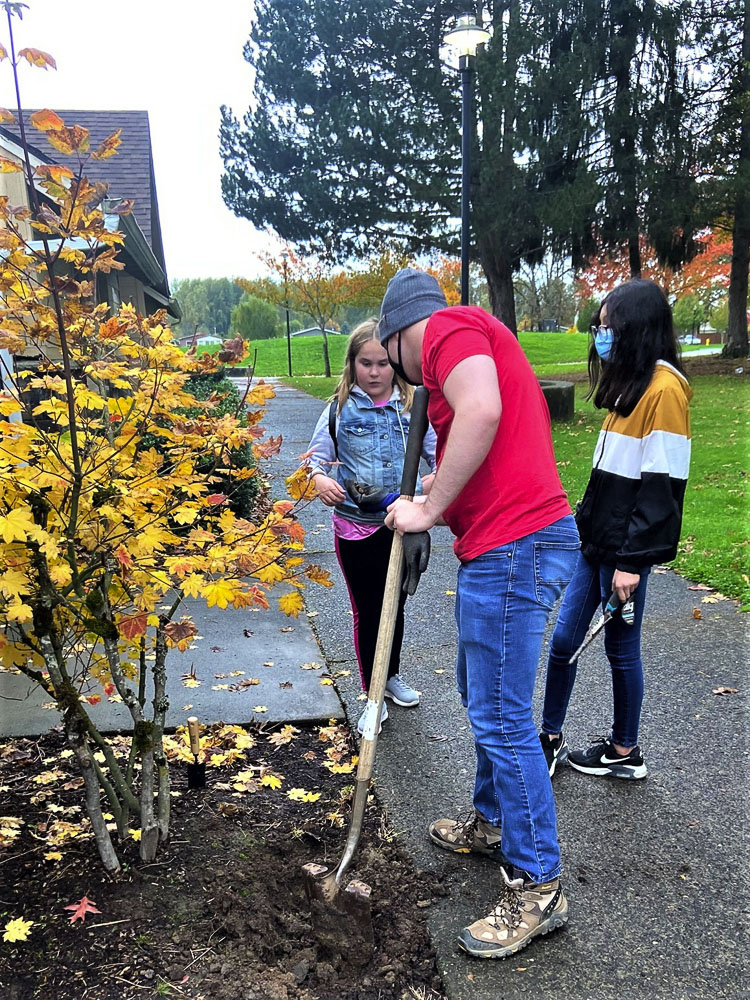 Rex Trefren of iQCU helps Rocksolid teens prepare planting beds at Kiwanis Park. Photo courtesy city of Battle Ground