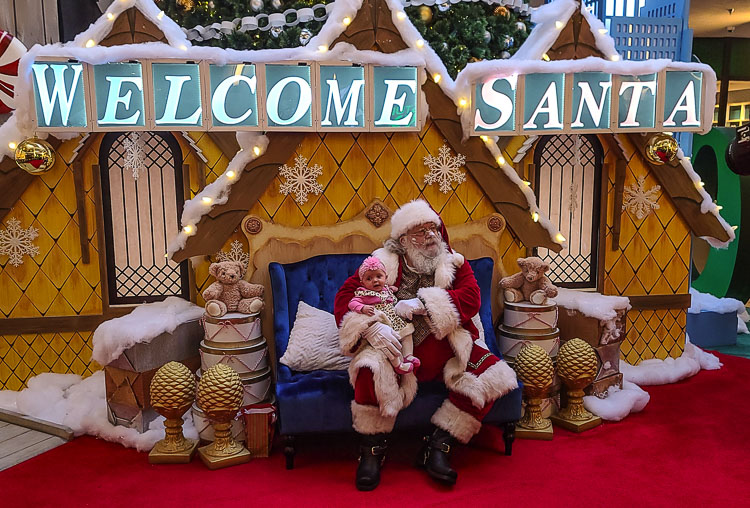 Alice Gandar gets her picture taken with Santa Claus at the Vancouver Mall recently. Her parents are Stevie Gandar and Julian Thomas. Photo by Paul Valencia