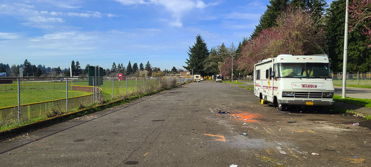 This photo, taken Friday morning, shows that only a couple vehicles remain in the parking lot. Many of the homeless camps outside Fort Vancouver High School were removed on Thursday. Photo by Paul Valencia