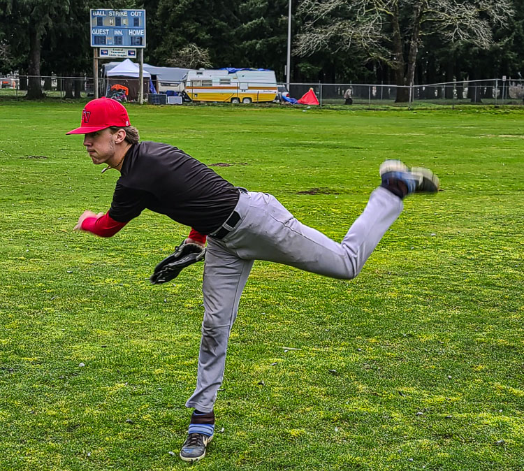 Fort Vancouver senior Dylan Brooks-Minck warms up on the practice field at his school, with a homeless camp on the other side of the fence. Photo by Paul Valencia