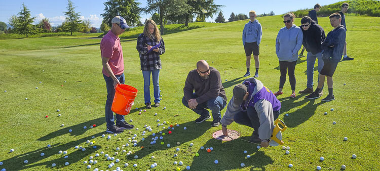 Organizers and volunteers try to determine the closest golf balls to the target after Saturday’s ball drop fundraiser for the La Center Community Stadium. Photo by Paul Valencia